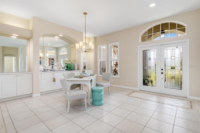 unfurnished dining area with light tile patterned floors, plenty of natural light, and french doors