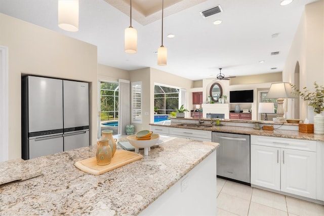 kitchen with sink, white cabinetry, light stone counters, decorative light fixtures, and stainless steel appliances