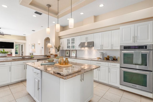 kitchen with white cabinetry, a center island, sink, and stainless steel double oven