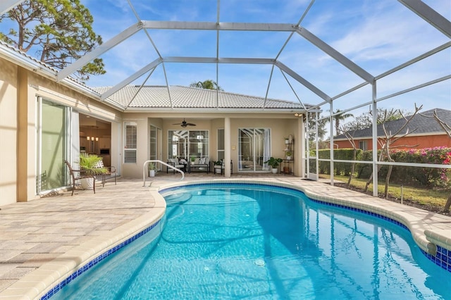 view of pool featuring a patio area, ceiling fan, and glass enclosure