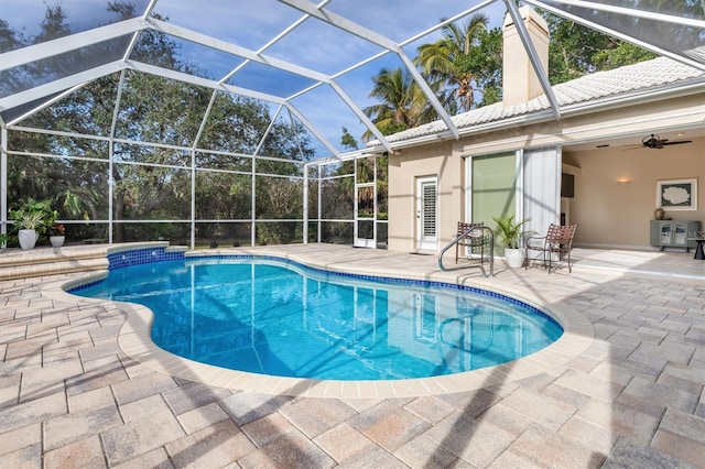 view of swimming pool featuring ceiling fan, a patio, and glass enclosure