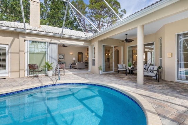 view of swimming pool featuring a patio, a lanai, an outdoor hangout area, and ceiling fan