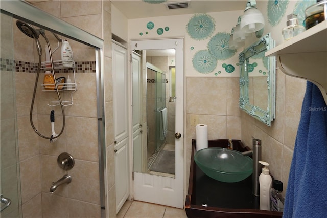 bathroom with an enclosed shower, vanity, tile patterned flooring, and tile walls