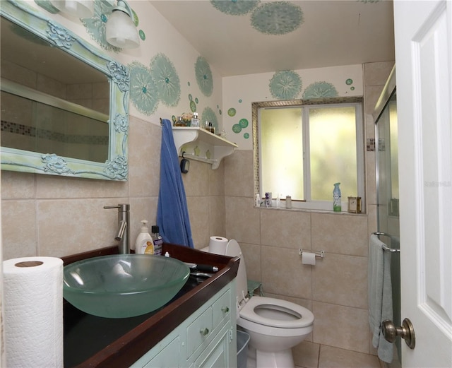 bathroom with walk in shower, vanity, toilet, and tile walls