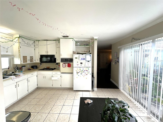 kitchen featuring sink, light tile patterned floors, black appliances, and white cabinets