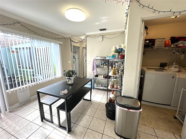 dining space with light tile patterned flooring, crown molding, and washer and dryer