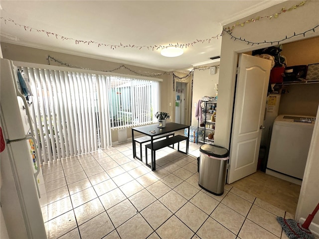 interior space featuring light tile patterned flooring, ornamental molding, washer / dryer, and white fridge