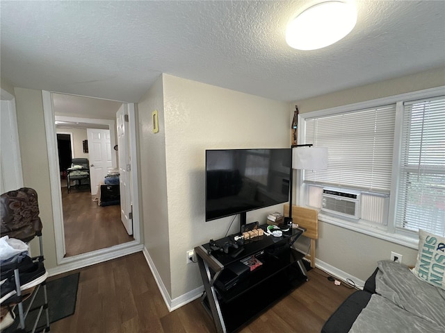 living room with dark wood-type flooring, cooling unit, and a textured ceiling