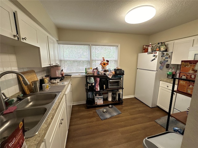 kitchen with dark wood-type flooring, sink, white cabinetry, a textured ceiling, and white appliances