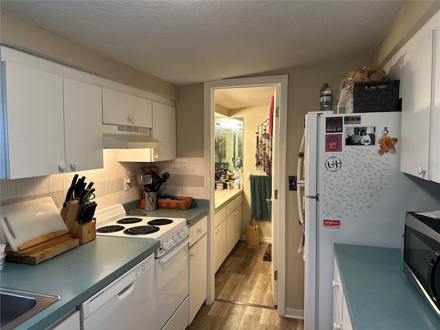 kitchen with white appliances, backsplash, light hardwood / wood-style floors, white cabinets, and a textured ceiling