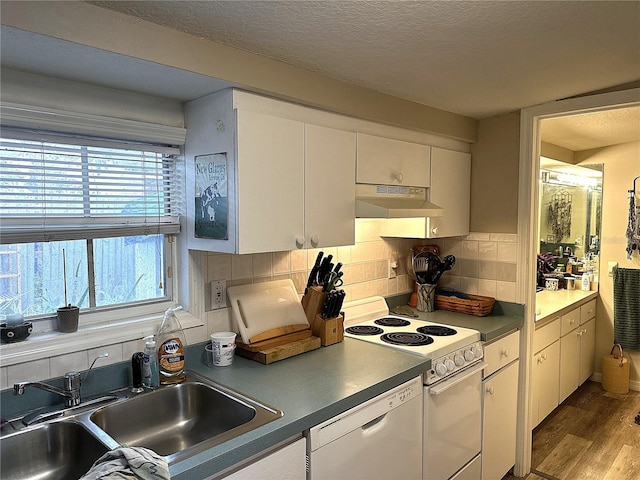 kitchen with white cabinetry, white appliances, light hardwood / wood-style floors, and sink