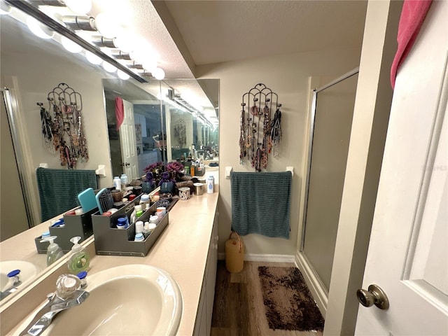 bathroom featuring hardwood / wood-style flooring, vanity, and an enclosed shower