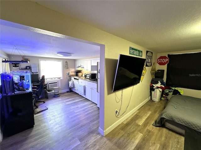 bedroom featuring light hardwood / wood-style floors and a textured ceiling