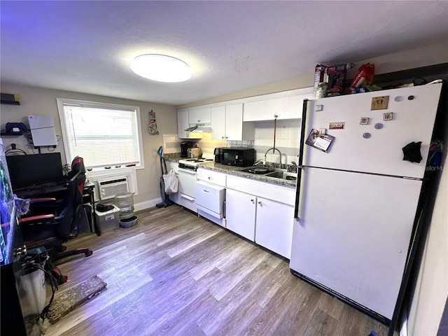 kitchen with a wall mounted air conditioner, sink, white cabinets, light hardwood / wood-style floors, and white appliances