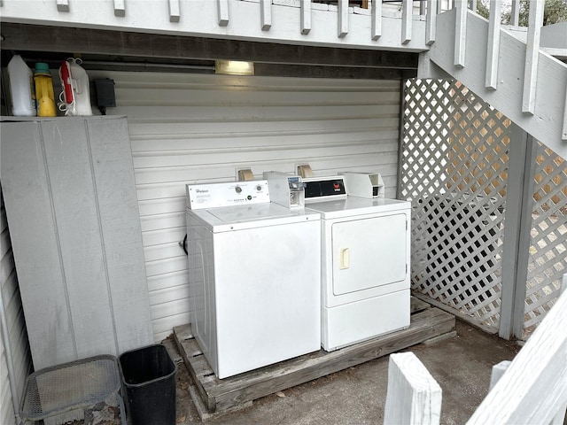 washroom featuring washing machine and clothes dryer and wooden walls