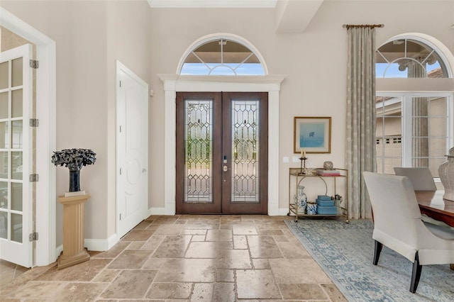 entryway featuring french doors and a towering ceiling