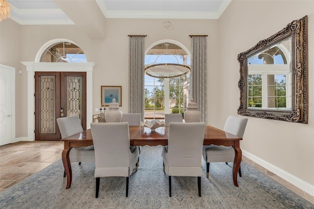 dining area with crown molding, french doors, and a towering ceiling