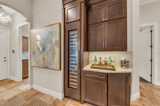 bar featuring hanging light fixtures, dark brown cabinetry, and decorative backsplash