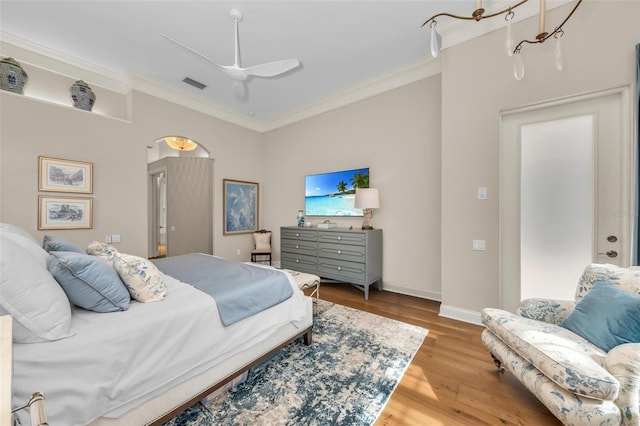 bedroom with ornamental molding, ceiling fan, and light wood-type flooring