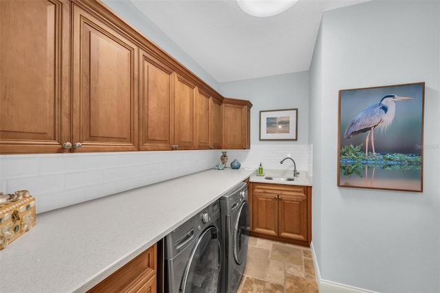 laundry area featuring separate washer and dryer, sink, and cabinets