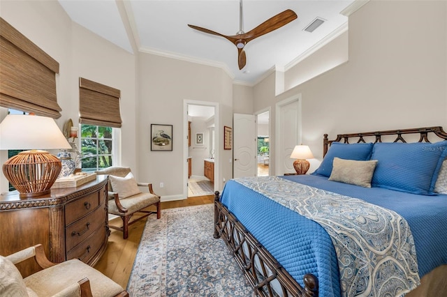 bedroom with ceiling fan, a towering ceiling, ensuite bathroom, ornamental molding, and light wood-type flooring