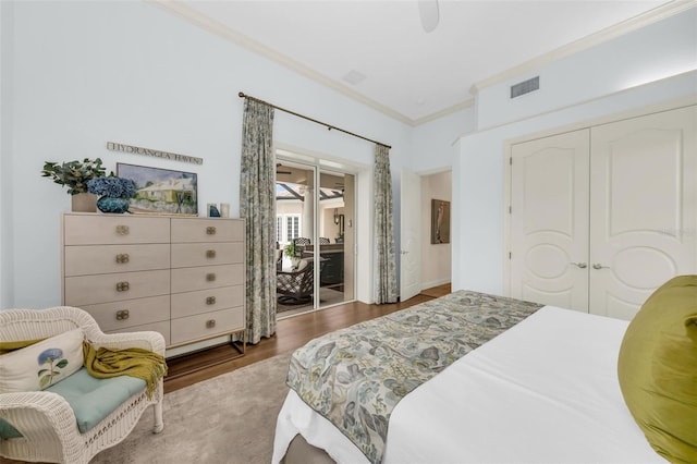 bedroom with visible vents, a ceiling fan, ornamental molding, dark wood-style flooring, and a closet