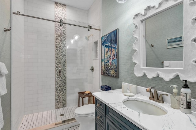 bathroom with vanity, toilet, and tiled shower