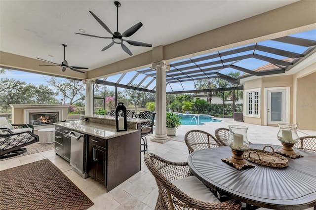 view of patio featuring pool water feature, ceiling fan, exterior bar, and a lanai