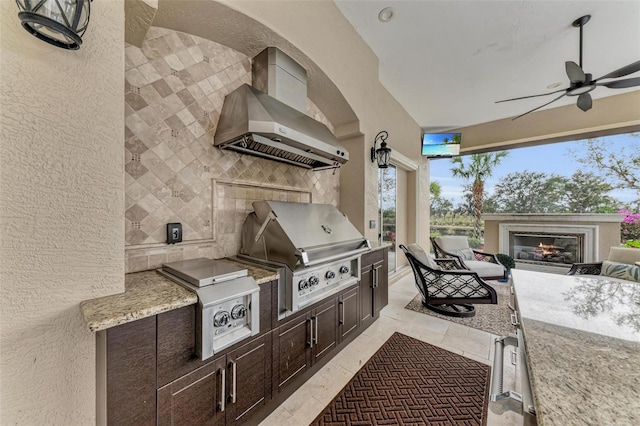 view of patio featuring ceiling fan, a grill, and exterior kitchen