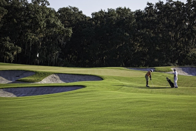 view of home's community featuring a lawn and golf course view