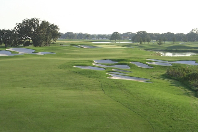 view of home's community with golf course view and a water view