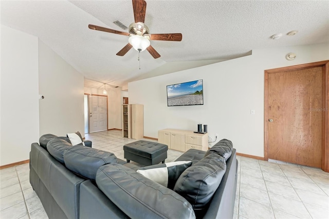 tiled living room featuring lofted ceiling, ceiling fan, and a textured ceiling