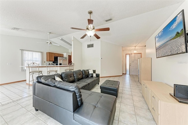 tiled living room with ceiling fan, lofted ceiling, and a textured ceiling