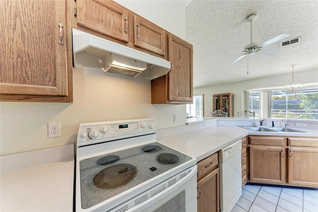 kitchen with sink, a textured ceiling, light tile patterned floors, white appliances, and ceiling fan with notable chandelier