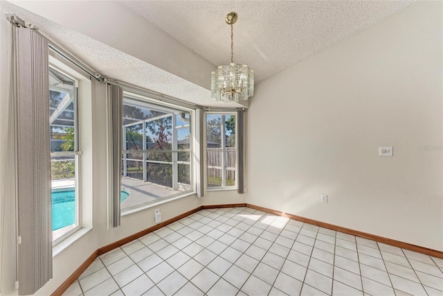 unfurnished dining area featuring light tile patterned floors, a textured ceiling, and a chandelier