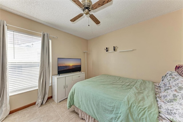 tiled bedroom with ceiling fan and a textured ceiling