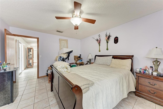 bedroom featuring ceiling fan, a textured ceiling, and light tile patterned floors