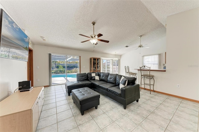 tiled living room with vaulted ceiling, plenty of natural light, ceiling fan, and a textured ceiling