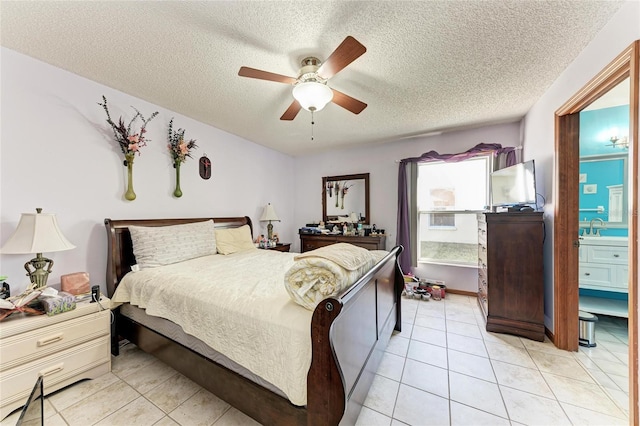 tiled bedroom with ceiling fan, sink, connected bathroom, and a textured ceiling