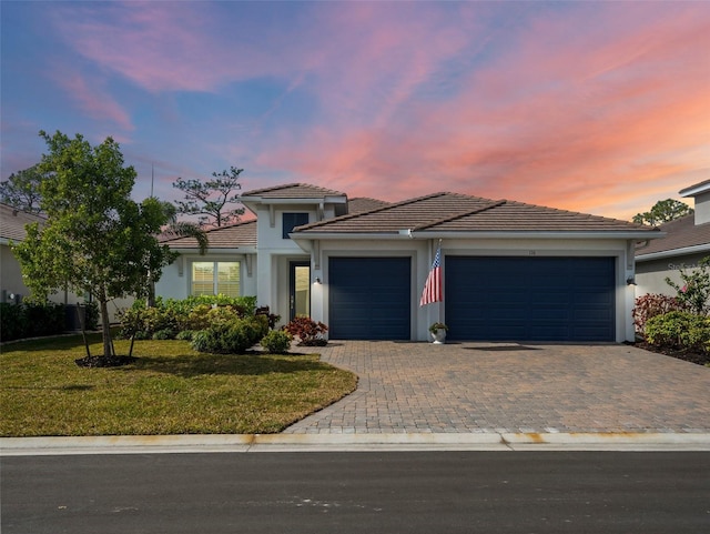 view of front of home with a yard and a garage