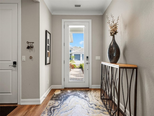 entryway featuring wood-type flooring and ornamental molding