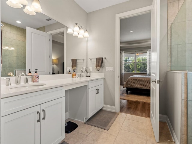 bathroom with tile patterned flooring, vanity, and a tile shower