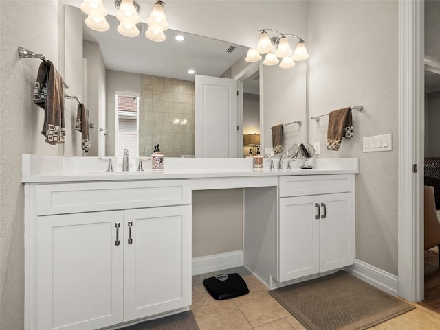 bathroom with a tile shower, vanity, and tile patterned floors