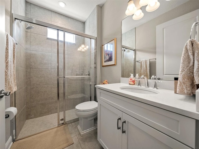 bathroom with vanity, a shower with shower door, tile patterned floors, and toilet