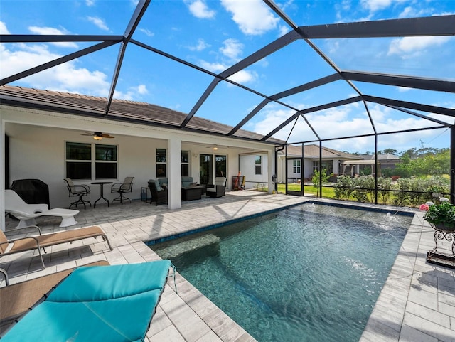 view of pool with pool water feature, an outdoor hangout area, ceiling fan, glass enclosure, and a patio area