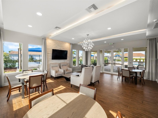 living room featuring a notable chandelier, dark wood-type flooring, french doors, and beamed ceiling