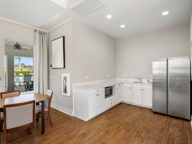 kitchen with sink, ceiling fan, white cabinetry, stainless steel appliances, and dark hardwood / wood-style flooring