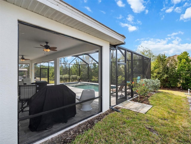 exterior space featuring ceiling fan, a lawn, glass enclosure, and a patio area