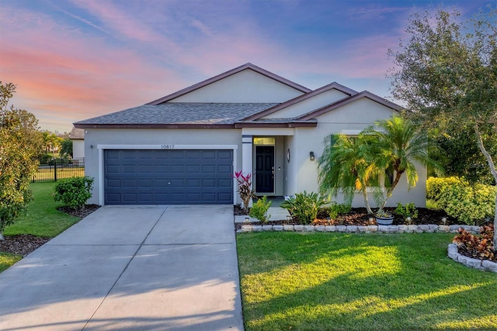 ranch-style house featuring a yard and a garage