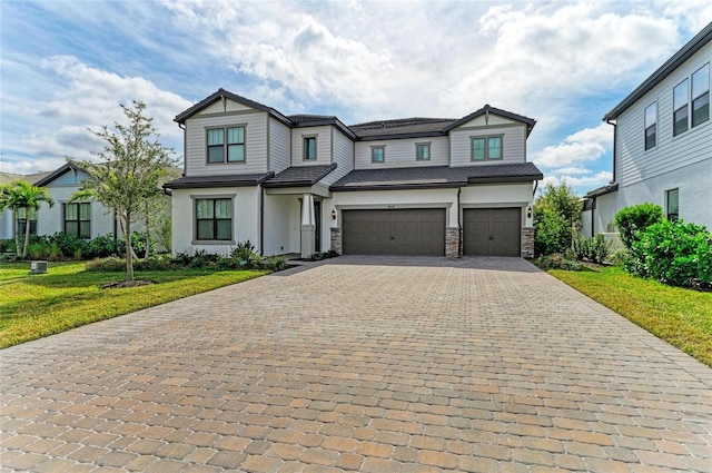 view of front facade with stone siding, a front lawn, decorative driveway, and an attached garage